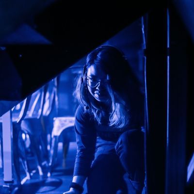 Stage Management student crouching down with props